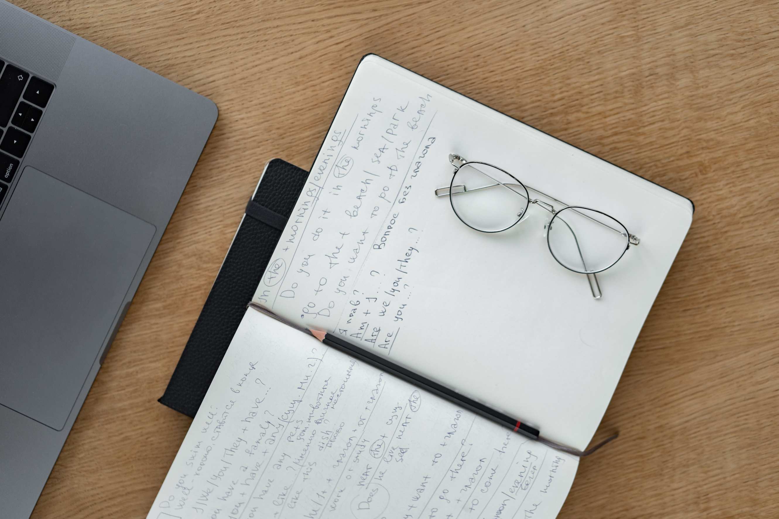Desk with handwritten notes and a system diagram sketch, with notebook and pen on an office workspace